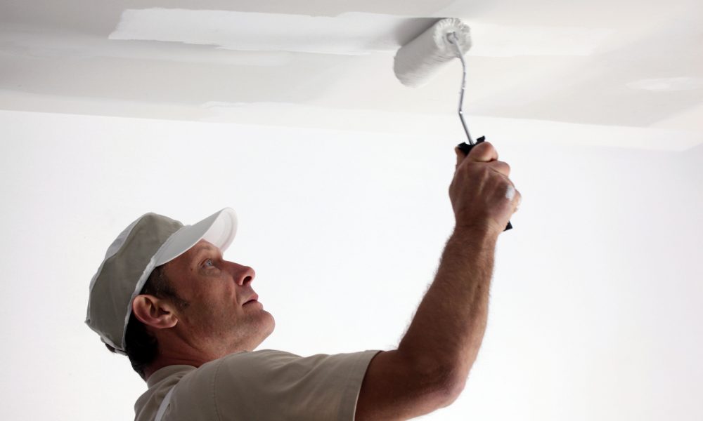 Tradesman painting a ceiling Tradesman painting a ceiling